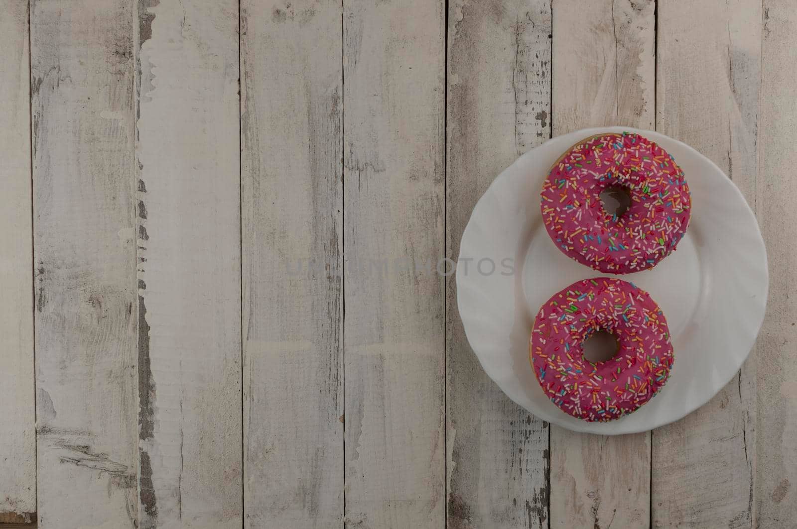 Donut on a plate and on a wooden table. Photo of sweets. Top view. Copy space. Mock-up
