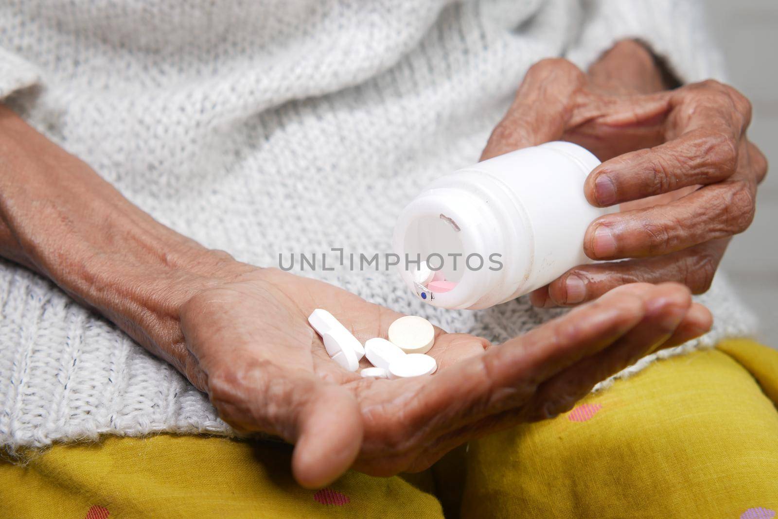senior women hand's taking medicine, close up .