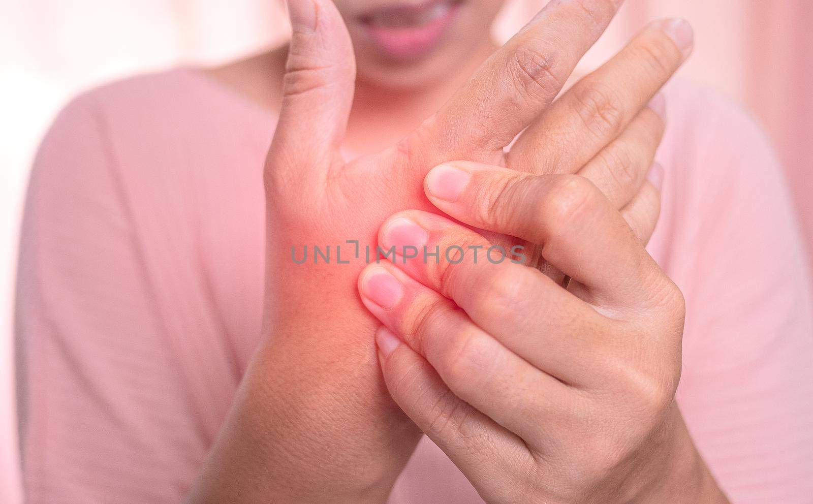 Closeup of female holding her painful palm and numbness caused by prolonged work on the computer or housewife, Carpal tunnel syndrome, arthritis. Neurological disease concept. by TEERASAK