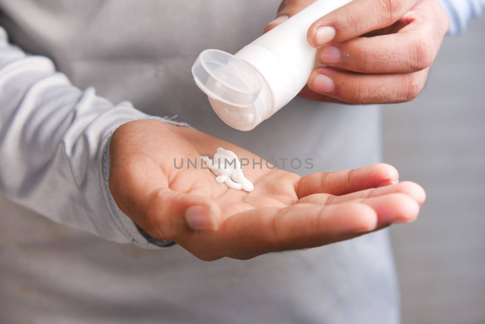 man applying beauty cream onto skin .