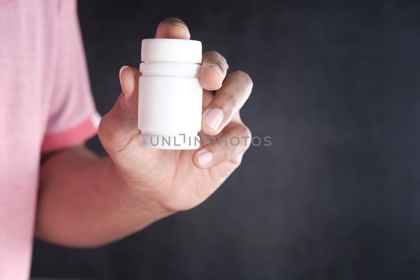 young man hand holding medicine pill container ,