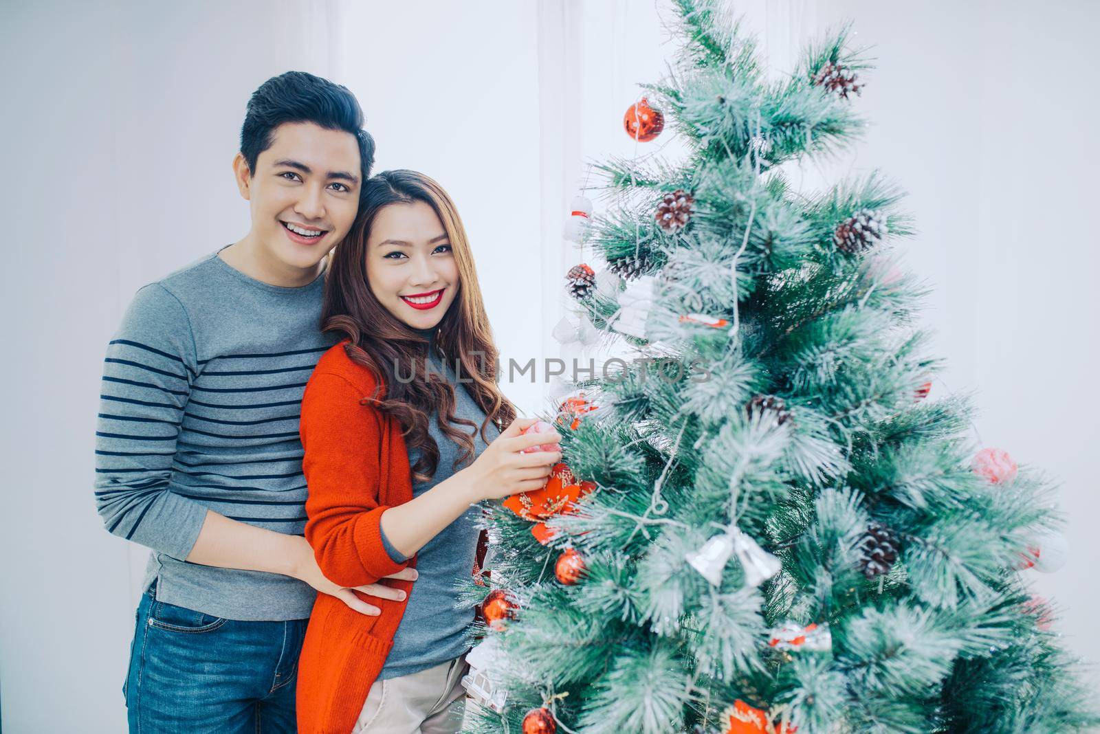 Christmas Asian Couple.Happy Smiling Family at home celebrating.New Year People by makidotvn