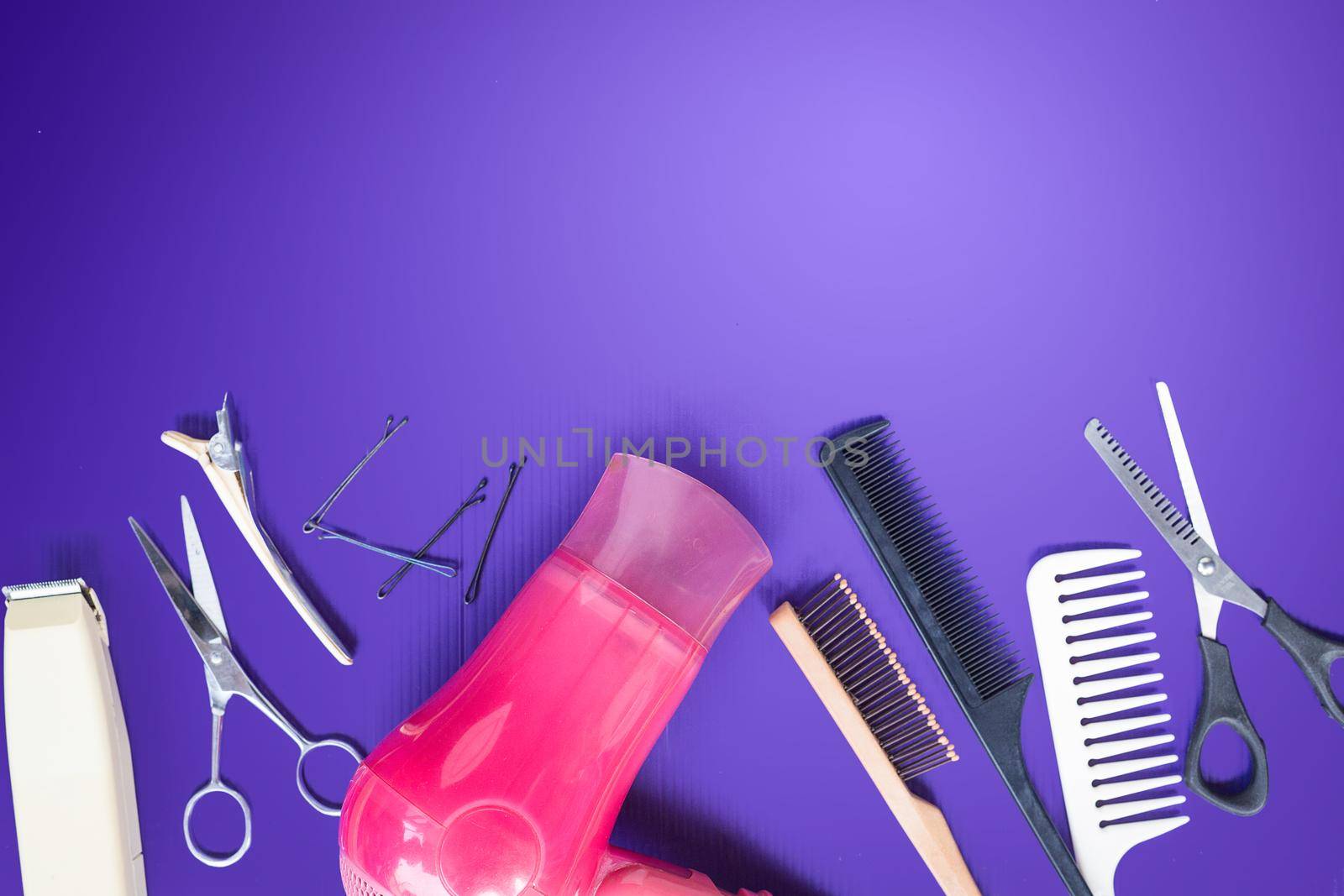 Hairdresser set with comb on top of purple background.