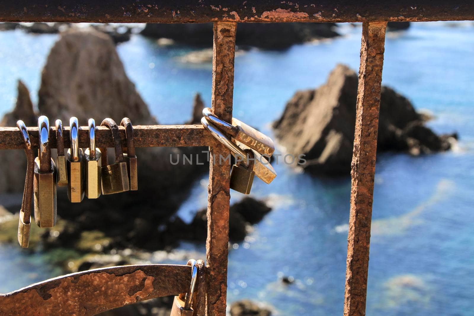Romantic padlocks hanging on The Reef of the Sirens railing in Cabo de Gata-Nijar, Almeria, Spain
