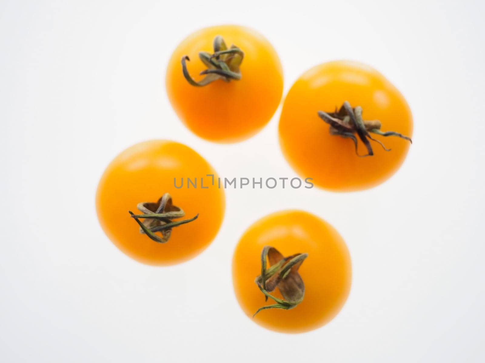 Healthy colourful yellow gold tomatoes cut out and isolated against a white background