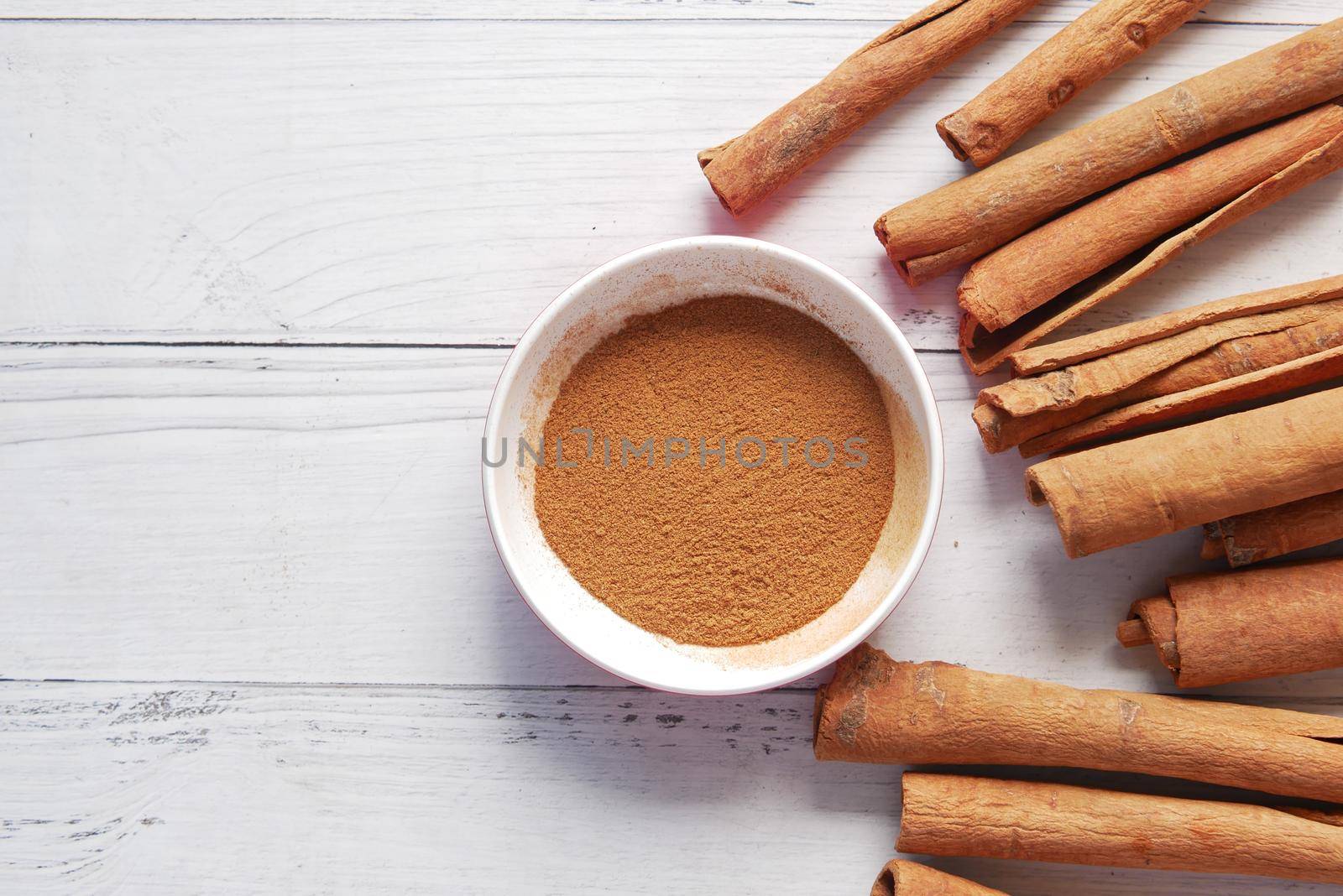 Cinnamon sticks and cinnamon powder on white background