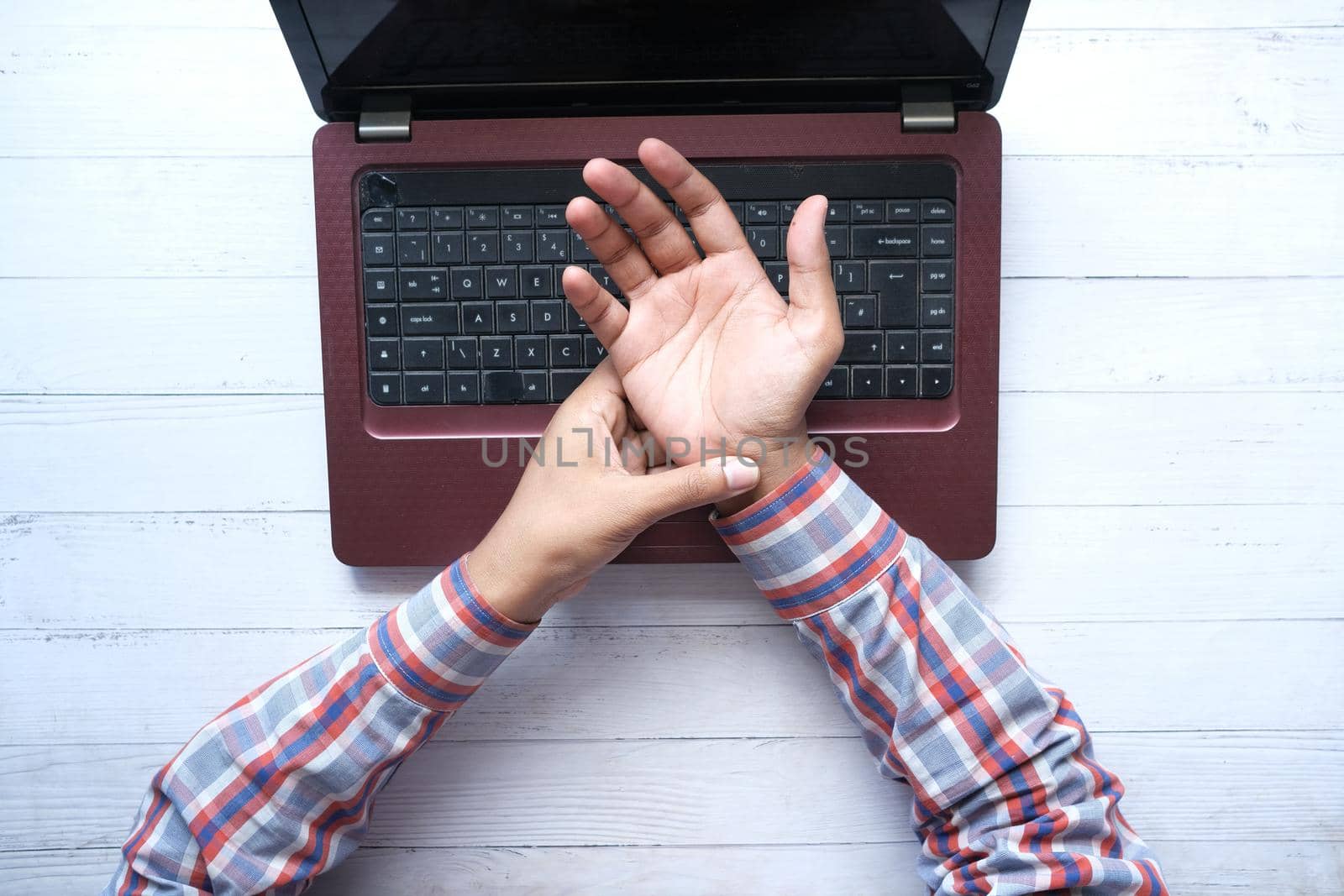 Young man in suffering wrist pain, close up.