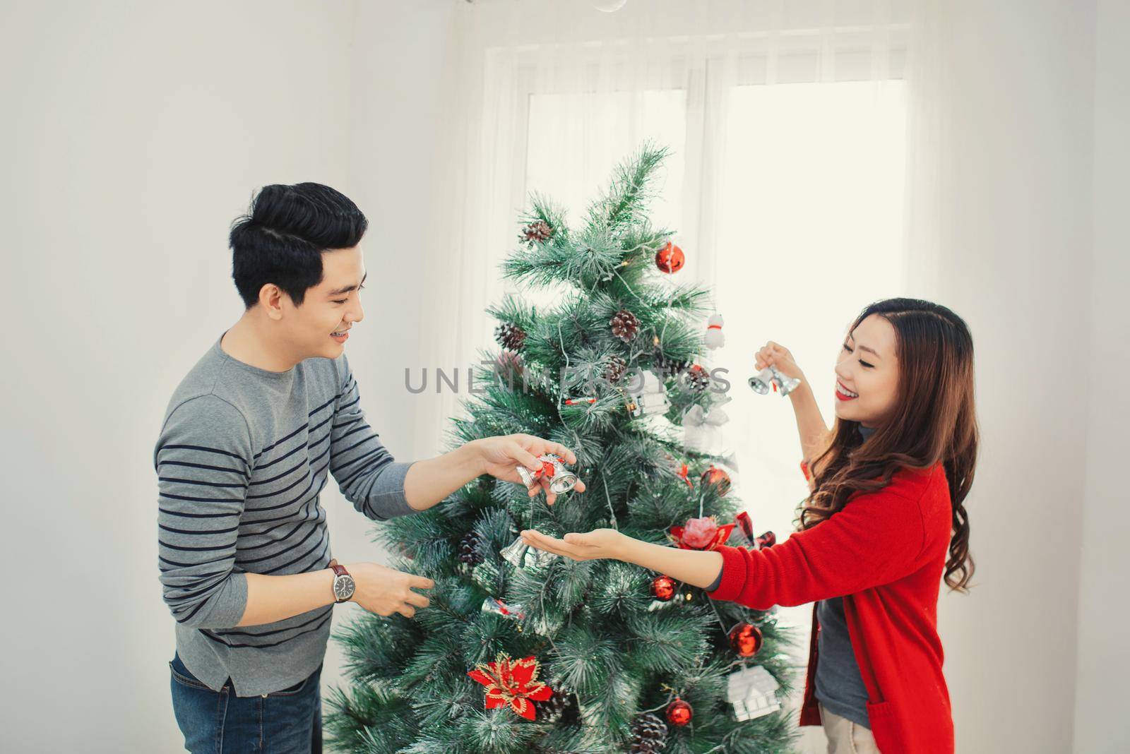 Christmas Asian Couple.Happy Smiling Family at home celebrating.New Year People