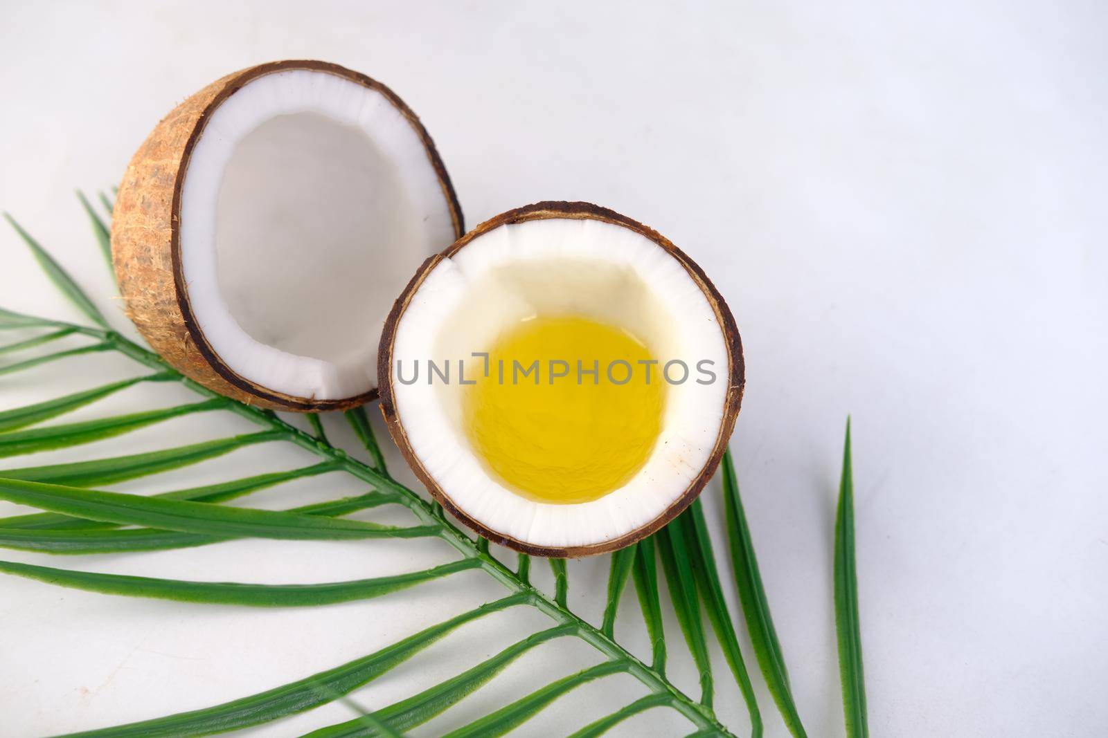 slice of fresh coconut and oil on white background with copy space
