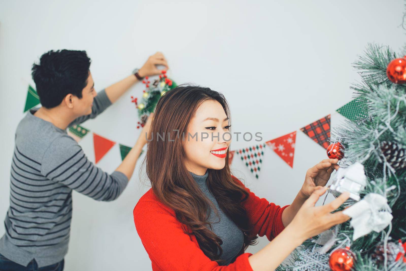 Christmas Asian Couple.Happy Smiling Family at home celebrating. New Year People