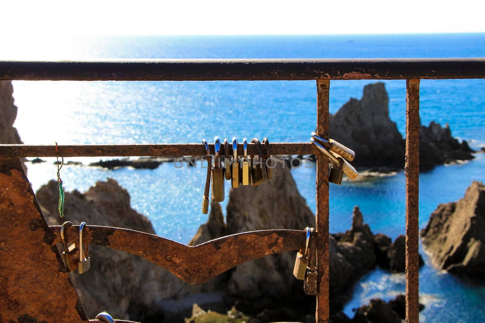 Romantic padlocks hanging on The Reef of the Sirens railing in Cabo de Gata-Nijar, Almeria, Spain