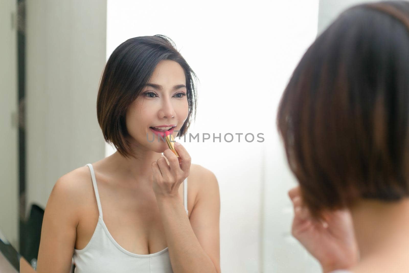 Beautiful woman with beauty face, Lips applying lip balm. by jayzynism