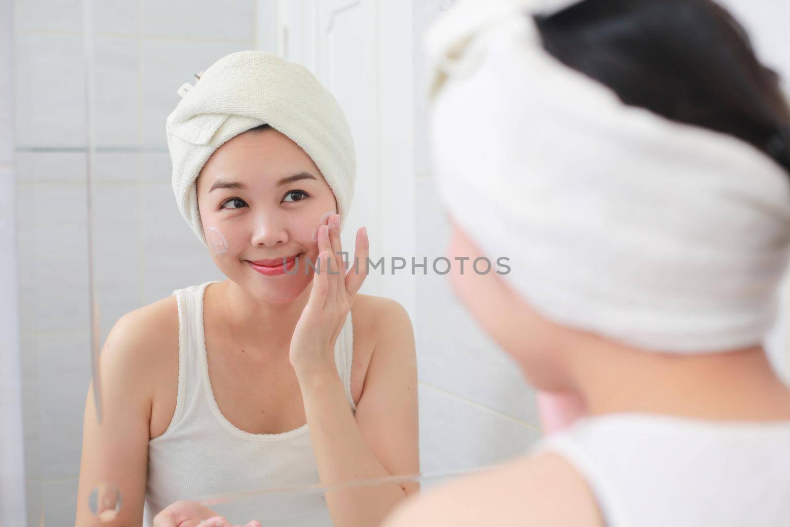 Woman happy cleanses the skin with foam on sink. by jayzynism