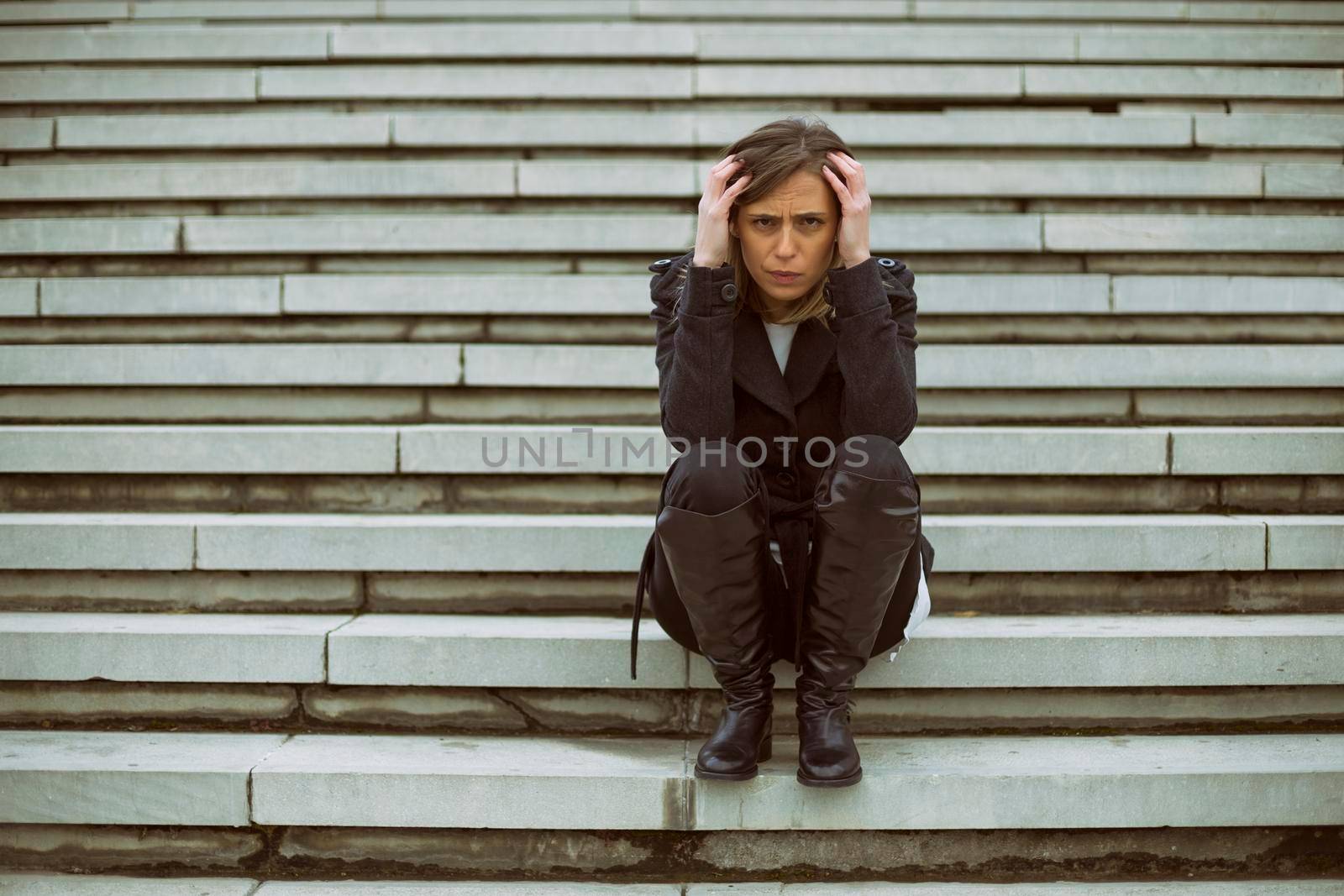 Frustrated businesswoman sitting on the staircase in the city.