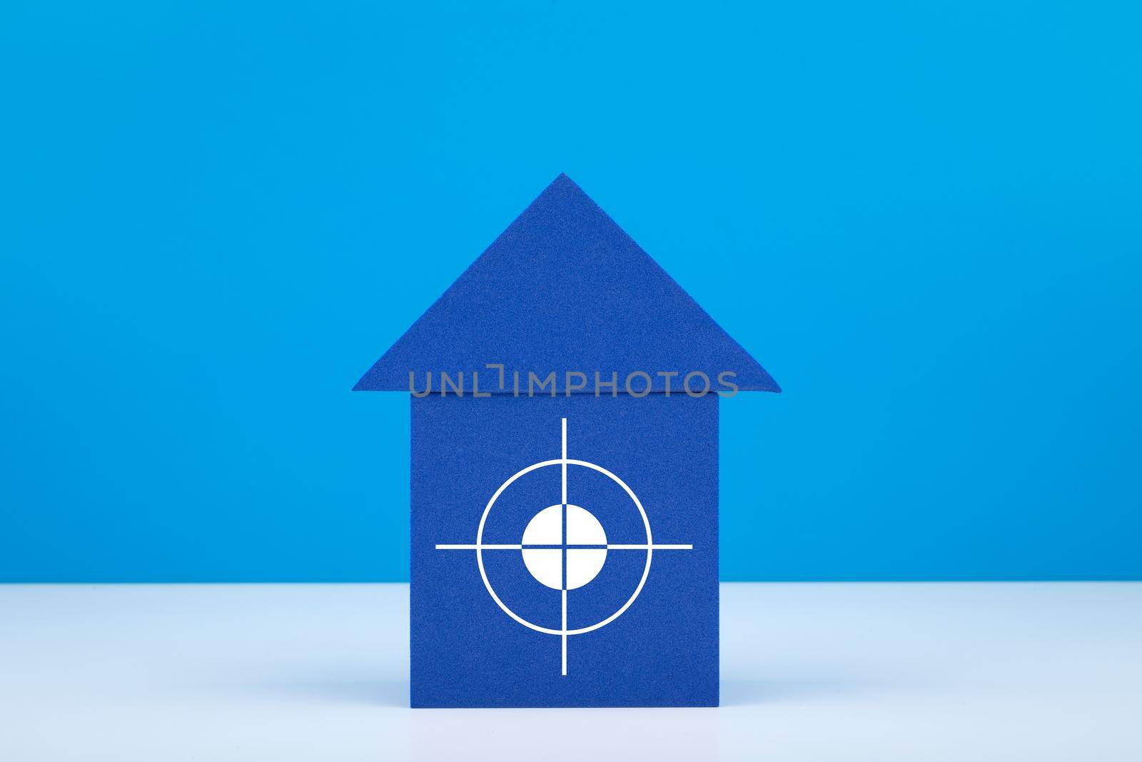 Blue toy house with target in the middle against blue background with copy space by Senorina_Irina