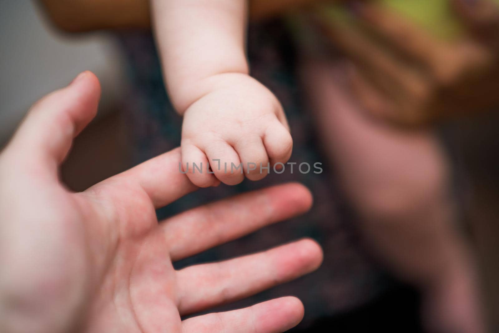 Image of  father's   and his baby boy son hands holding each other. Focus on fingers. by Bazdar
