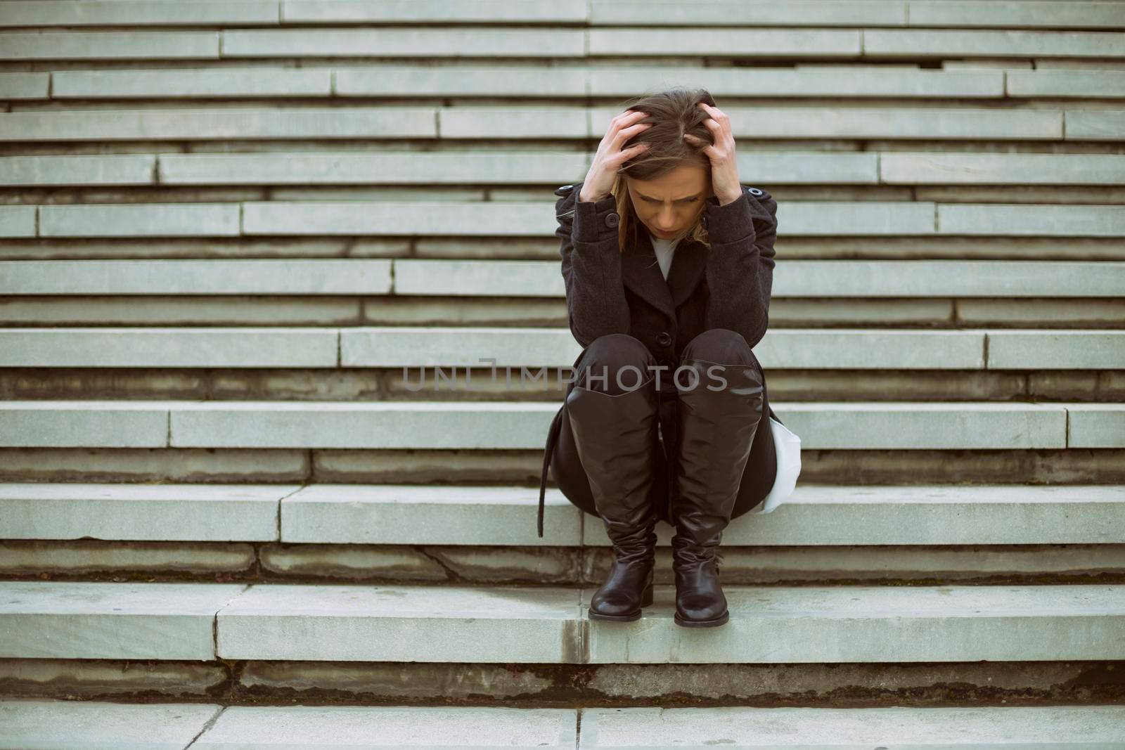 Frustrated businesswoman sitting on the staircase in the city.