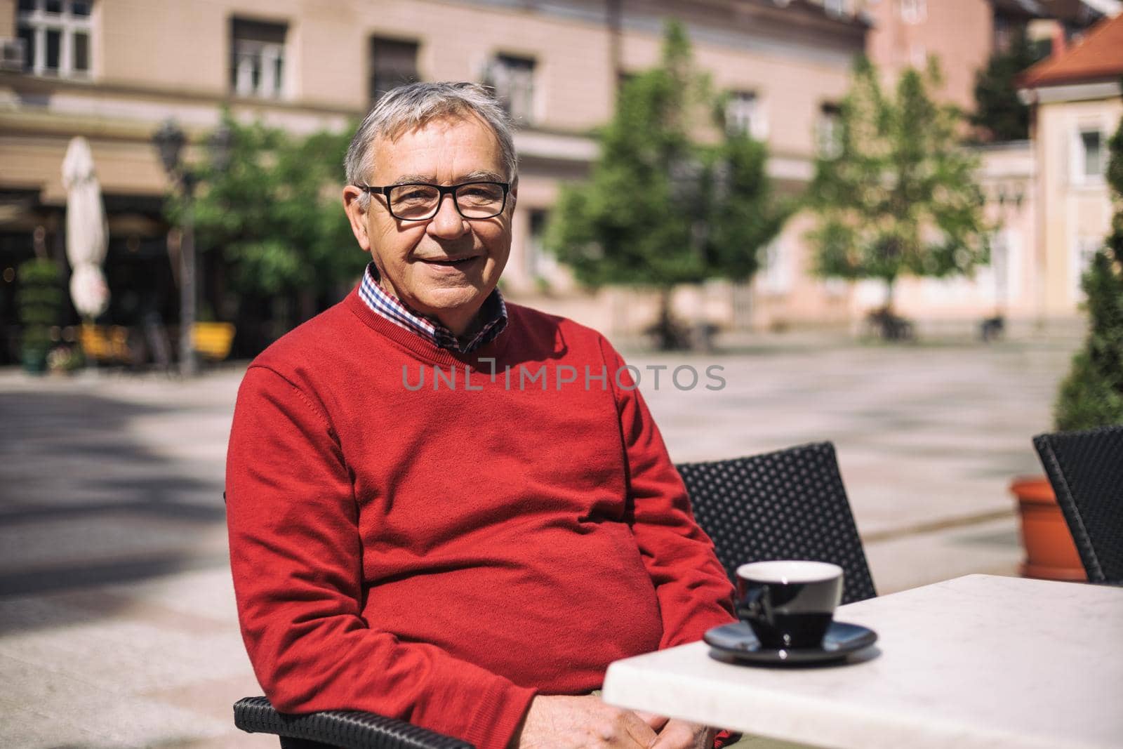 Cheerful senior man enjoys drinking coffee at the bar.Image is intentionally toned.