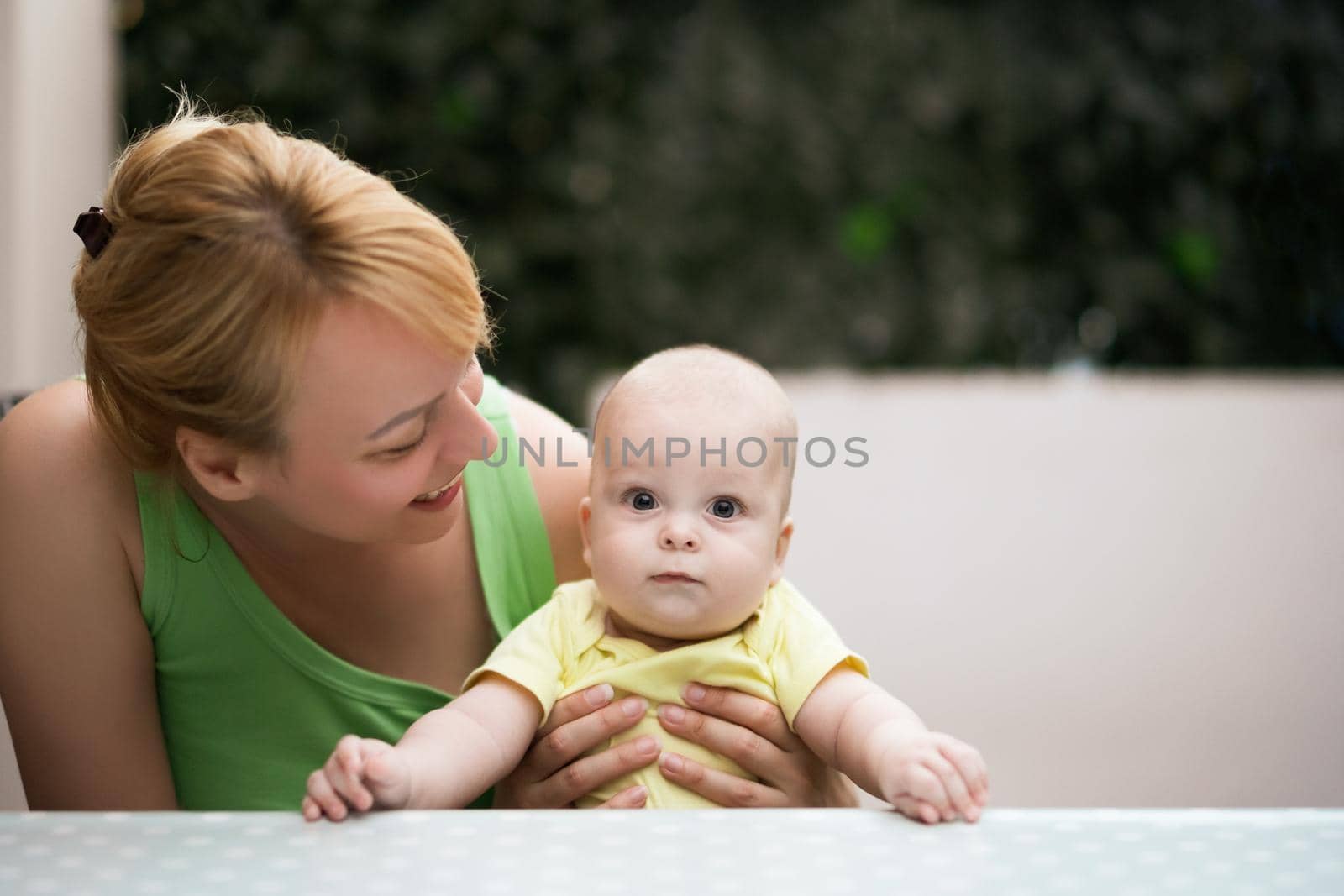 Mother enjoys spending time with  her little cheerful baby boy.