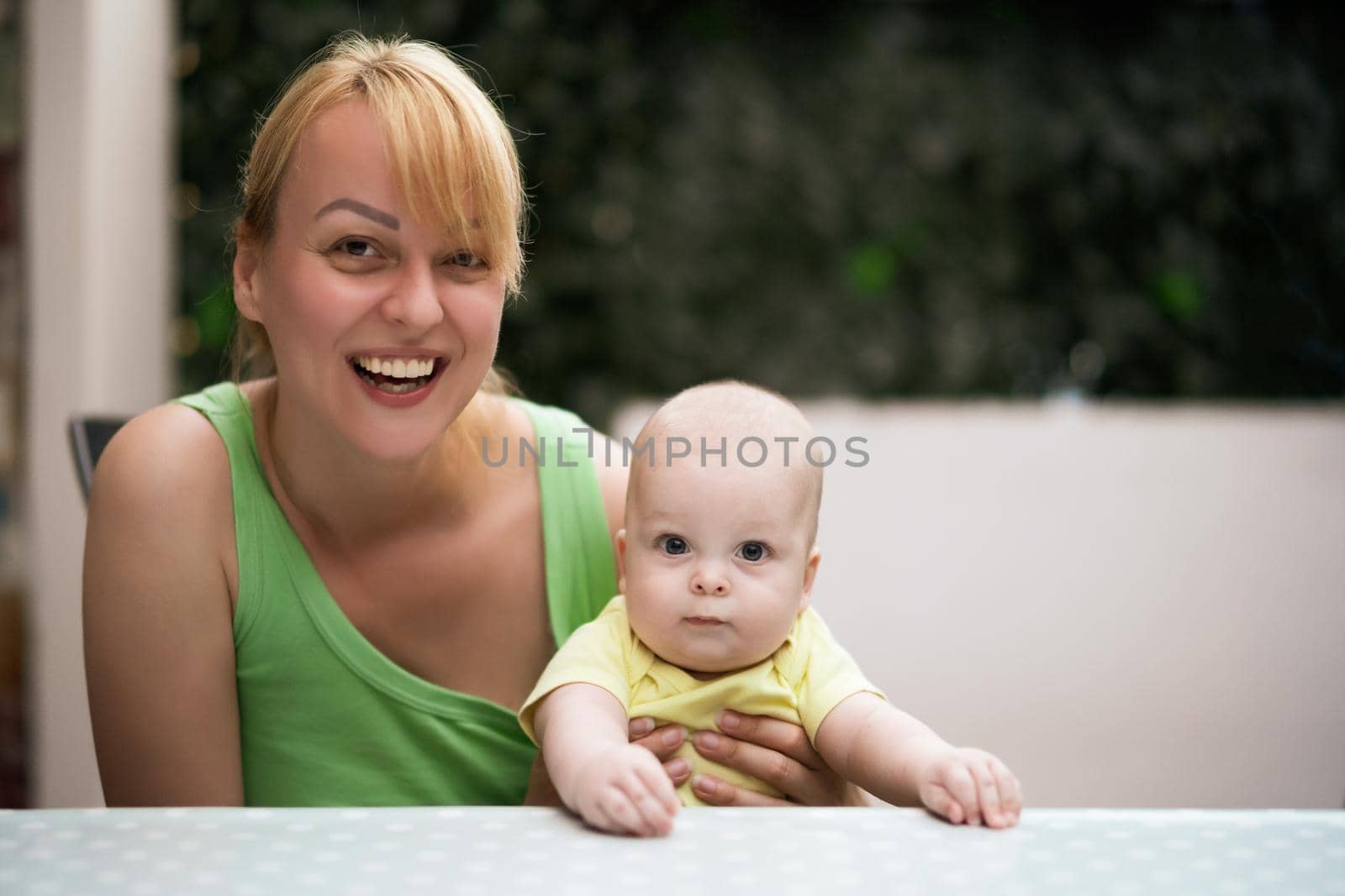 Mother enjoys spending time with  her little cheerful baby boy.