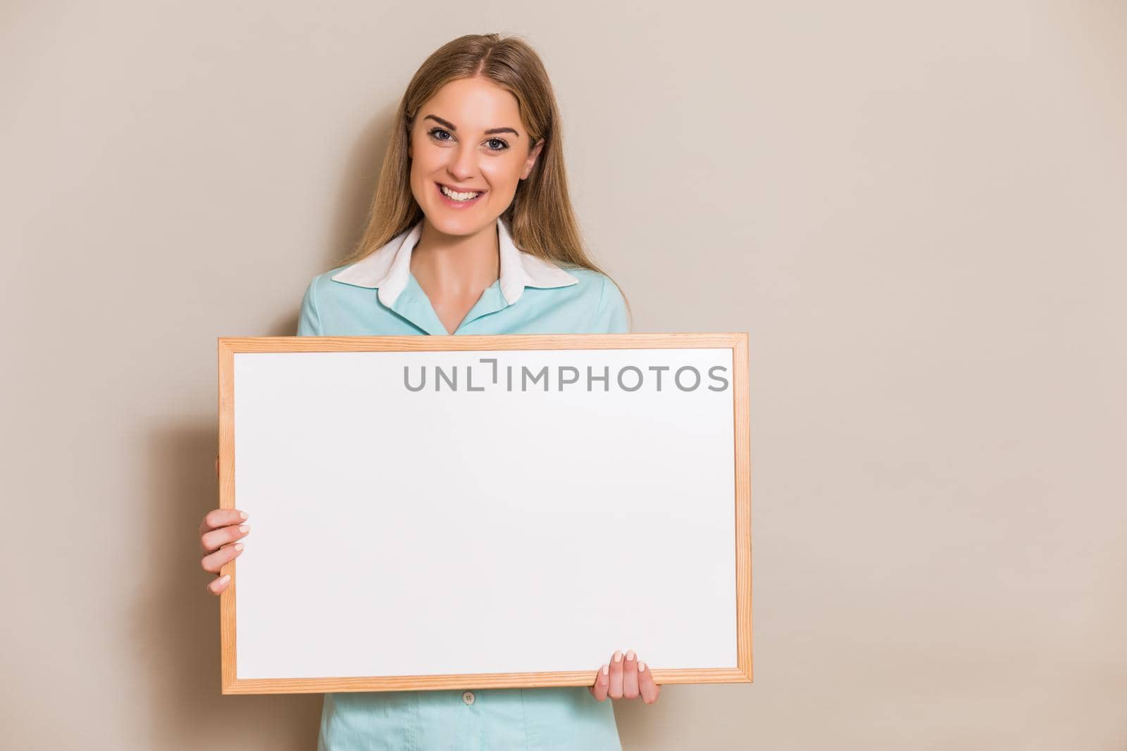 Portrait of medical nurse holding whiteboard.