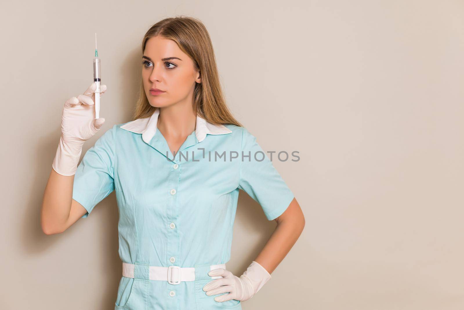 Portrait of medical nurse holding injection.