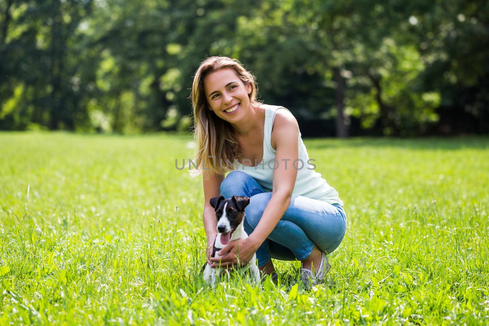Woman spending time in the nature with her dog Jack Russell Terrier by Bazdar