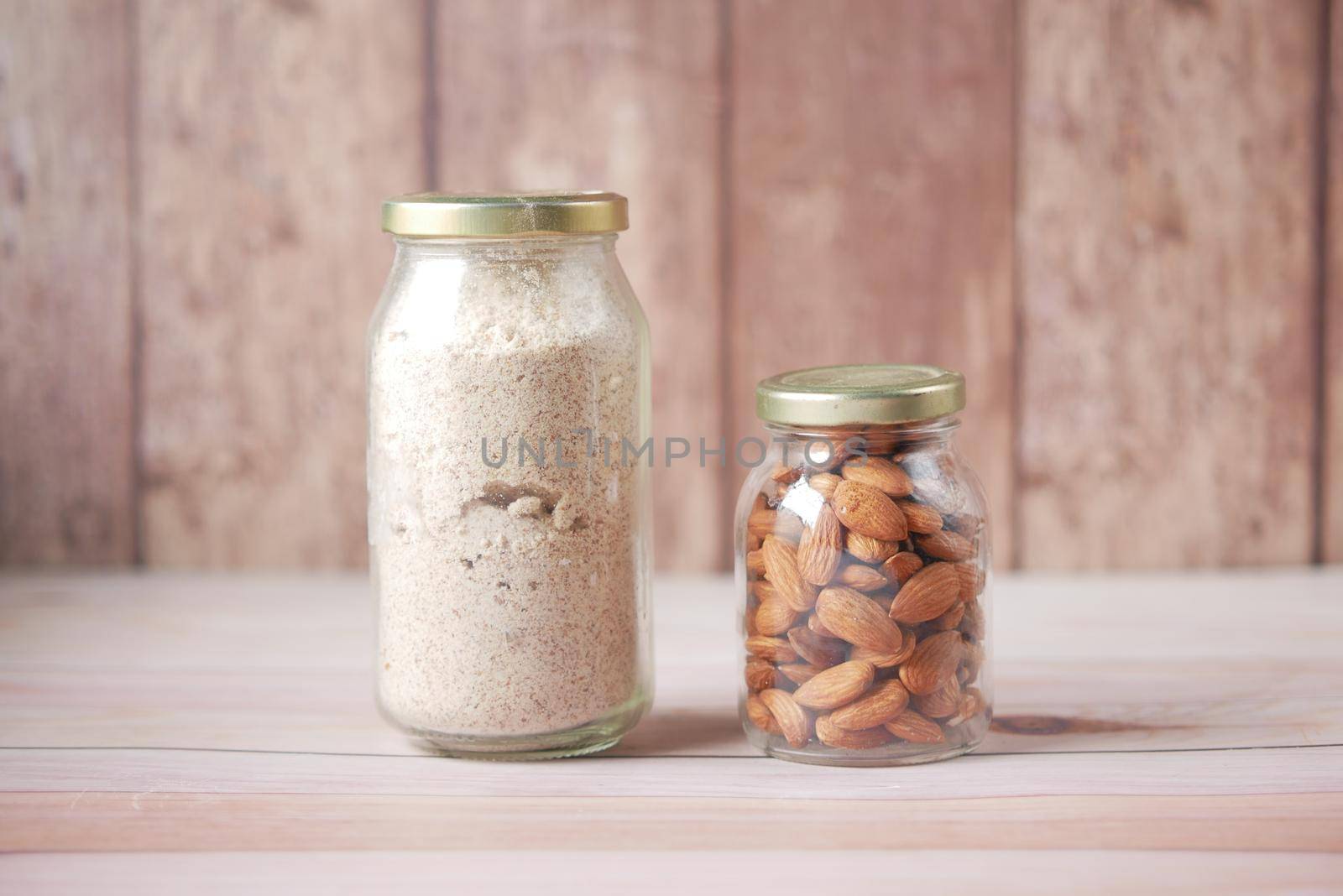 almond powder and almond in a jar on table