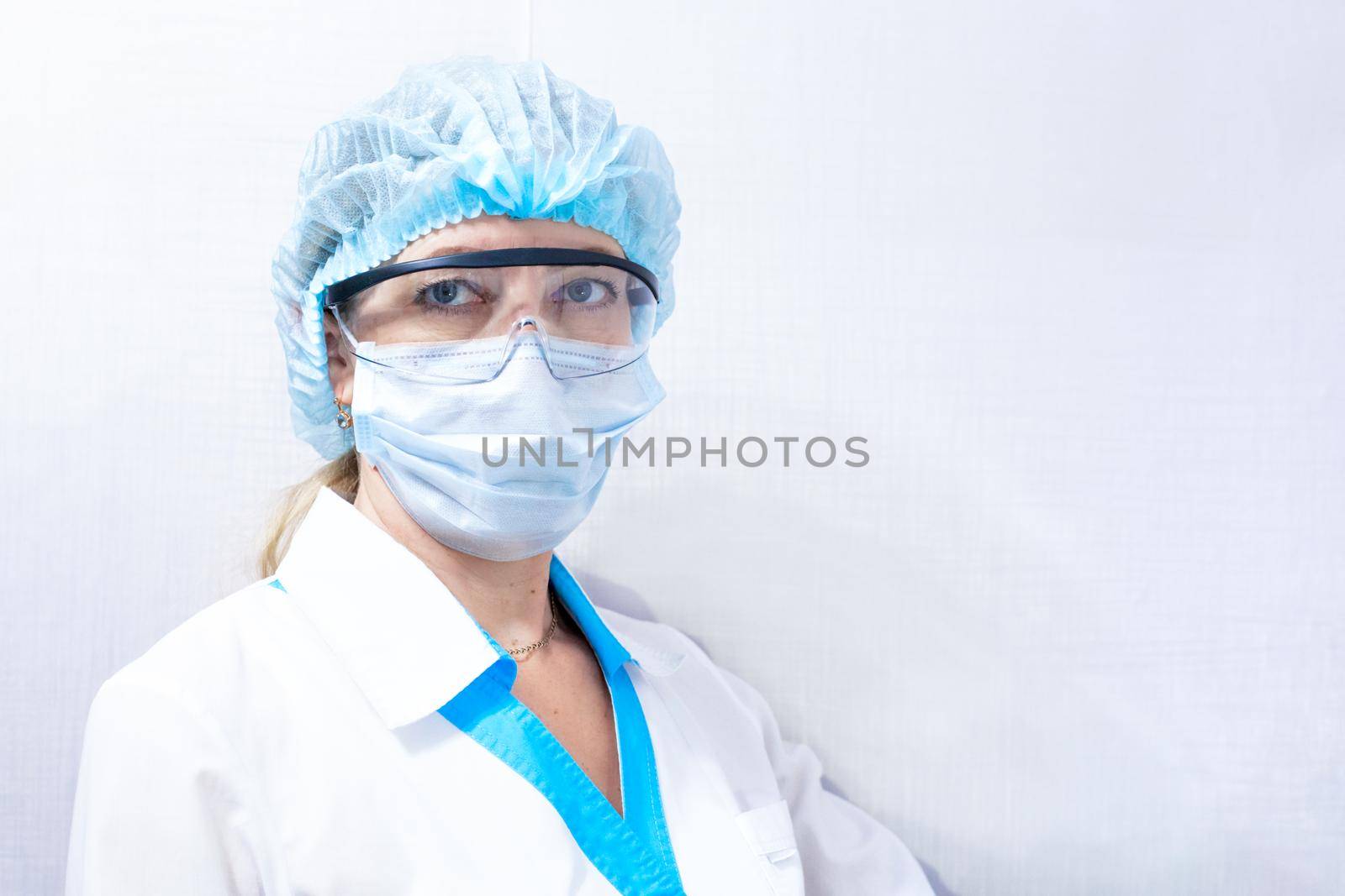 female doctor in medical mask, hat and goggles by levnat09