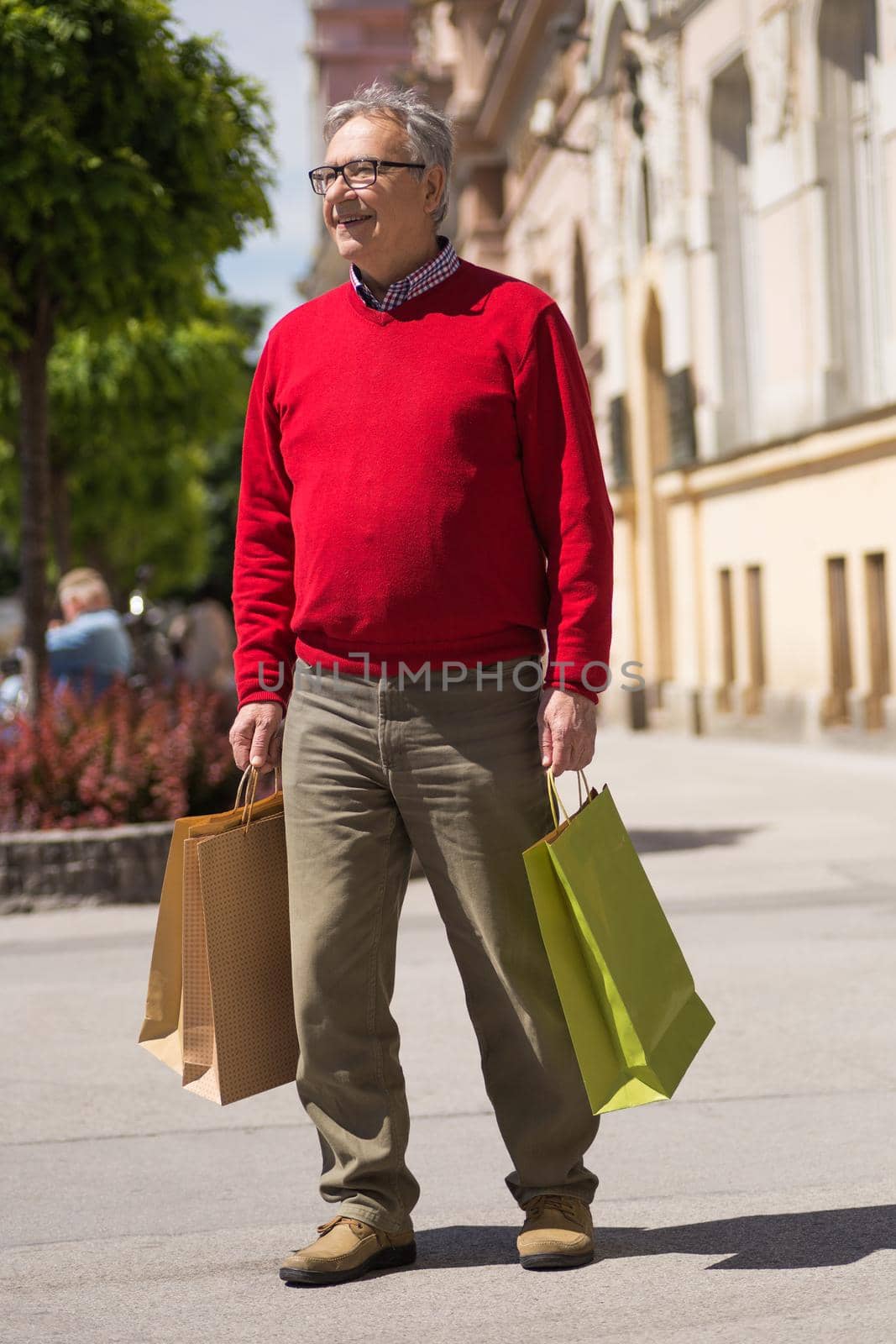 Senior man enjoys in shopping at the city.Image is intentionally toned.