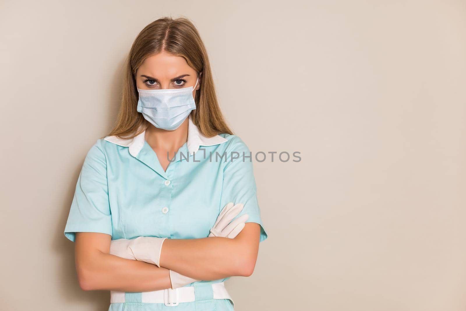 Portrait of angry nurse with protective mask and gloves.
