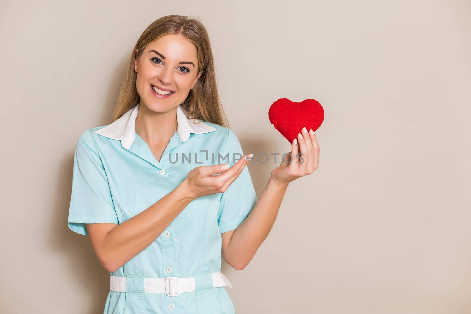 Portrait of medical nurse holding red heart.