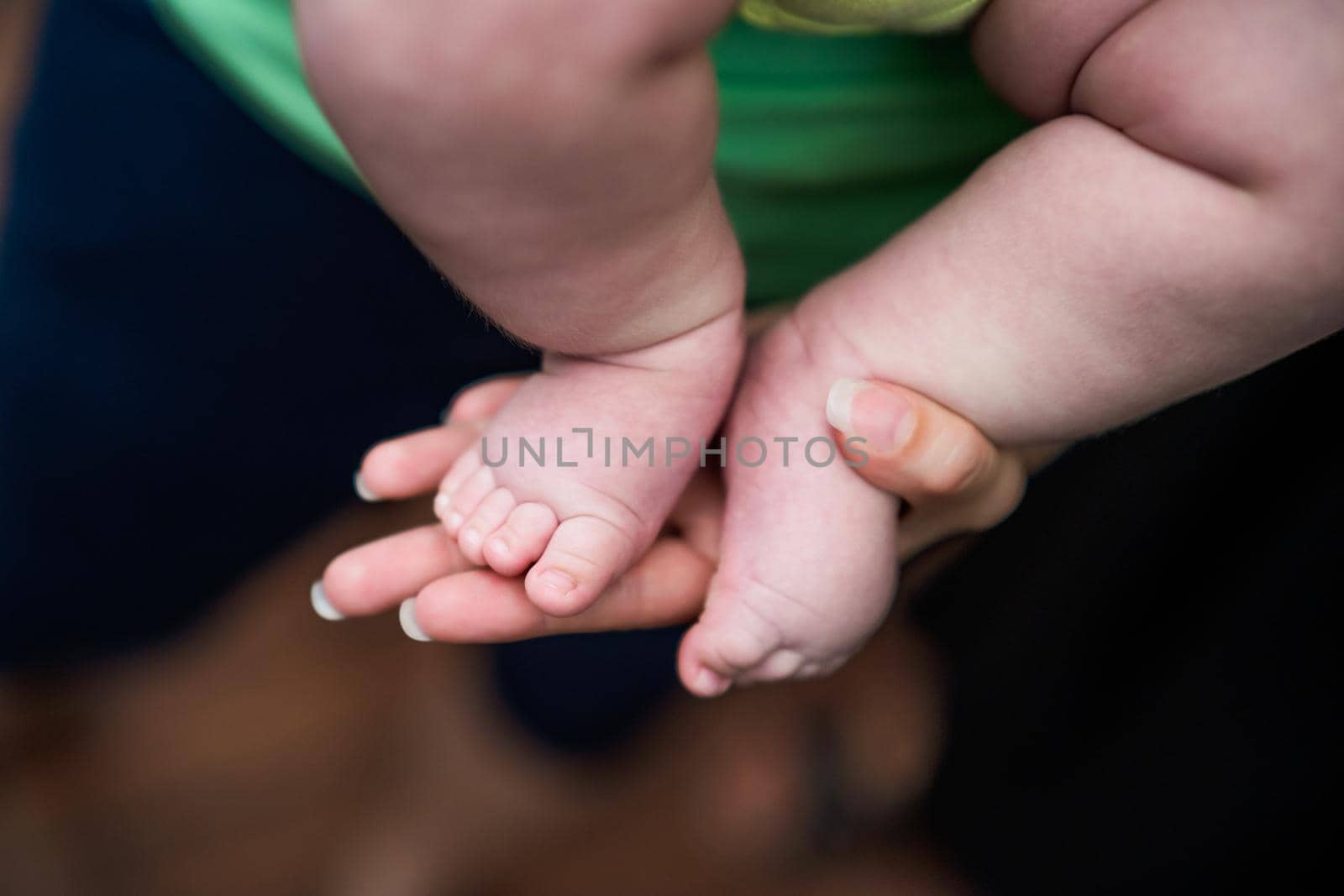 Image of little baby  legs in mother hands by Bazdar