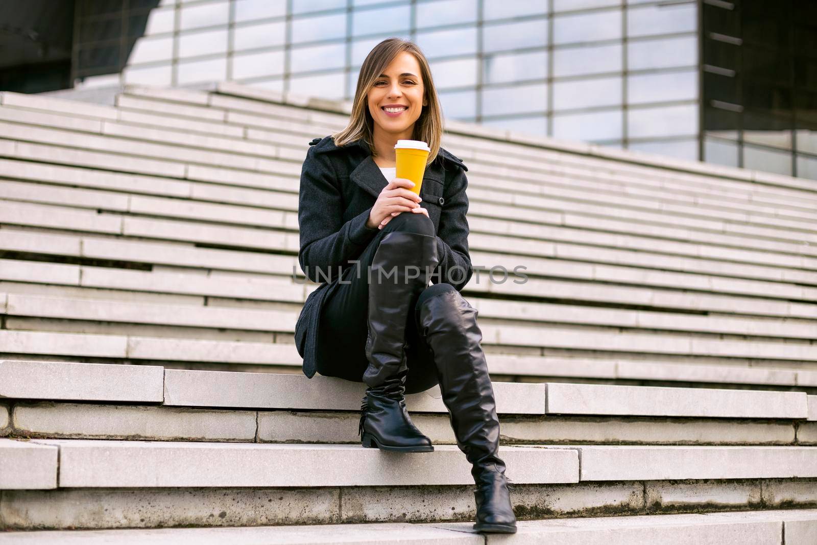 Businesswoman drinking coffee outdoor by Bazdar