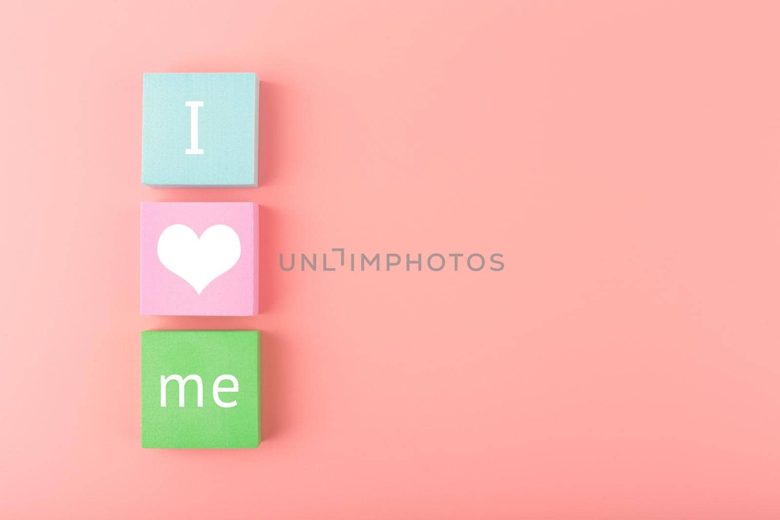 Trendy minimal I love me creative concept of self love and mental health or being single. Multicolored blocks with text against pastel pink background with copy space