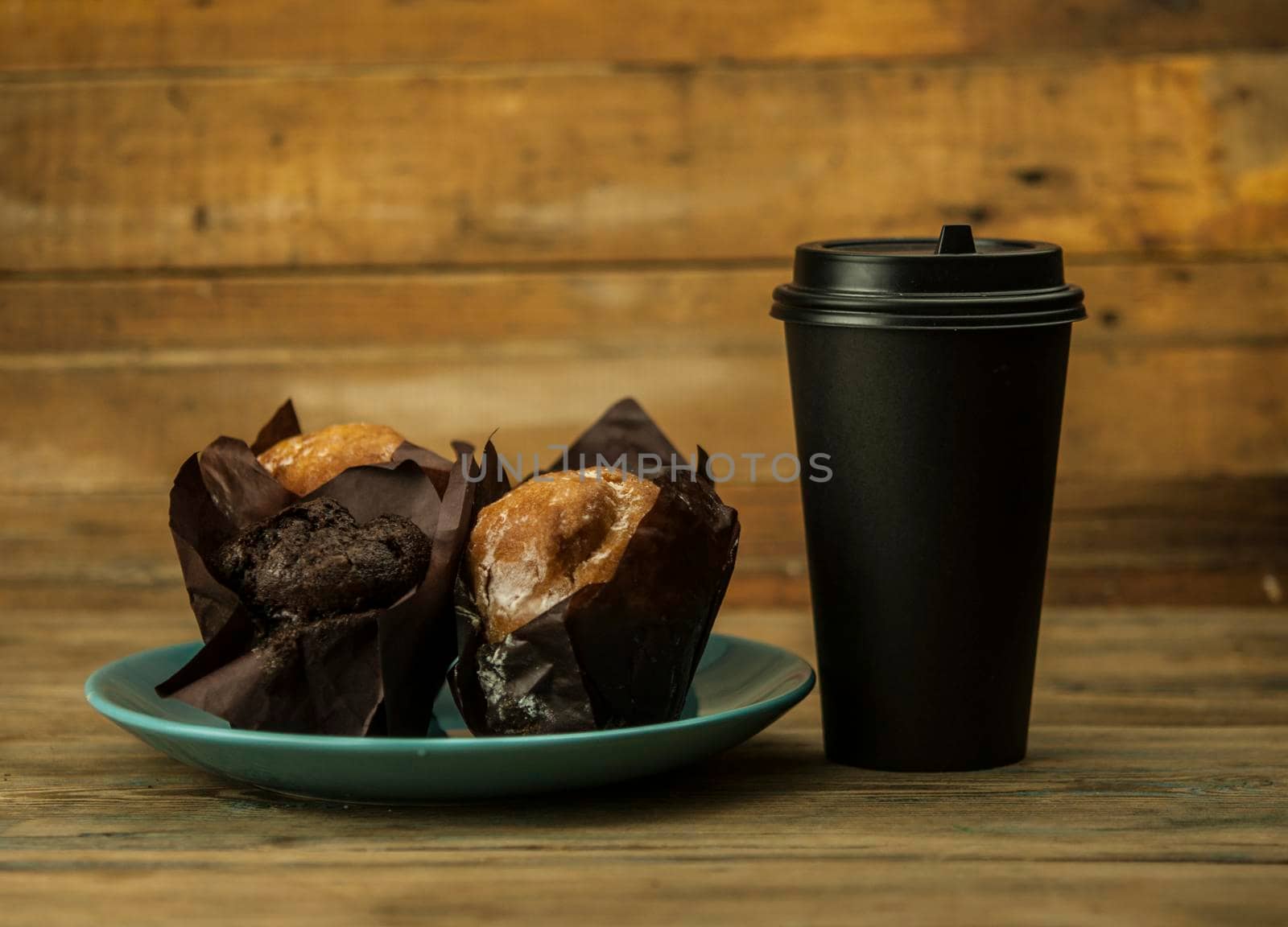 Homemade chocolate and vanilla cupcakes with paper disposable coffee cup on a wooden table, sprinkled with powdered sugar. Breakfast by inxti