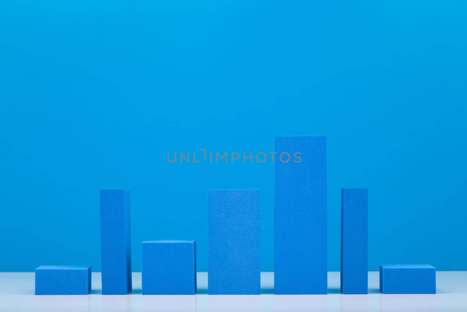 Business graph diagram with blue bars with rise and fall dynamic against blue background by Senorina_Irina