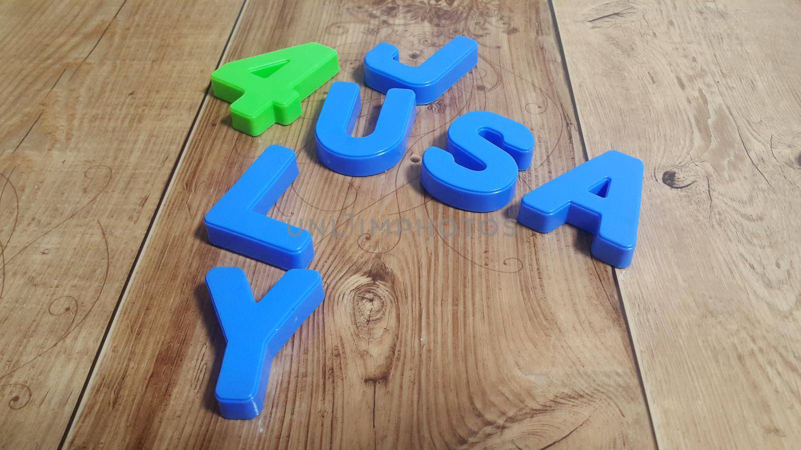 Plastic colored alphabets making words 4 july USA are placed on a wooden floor by Photochowk