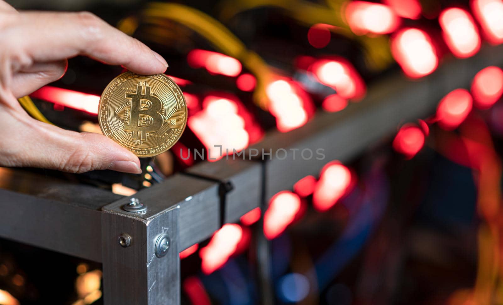 Hand holding bitcoin on Bitcoin mining farm background