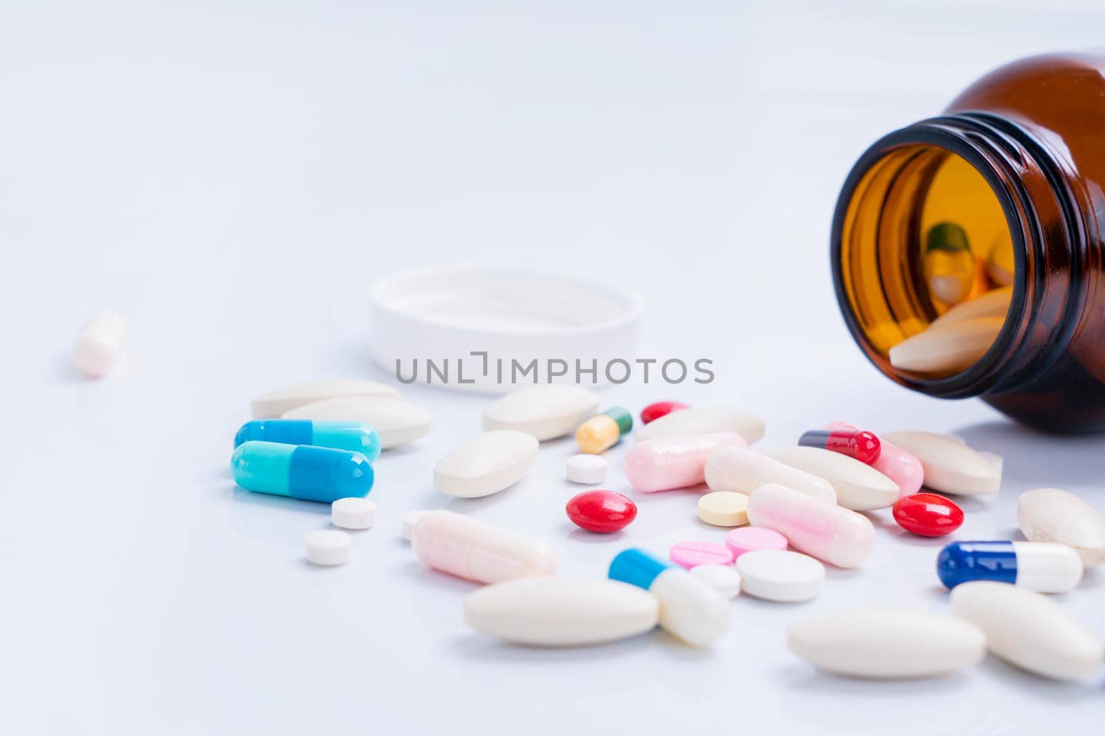 Pills spilling out of bottle on isolated white background
