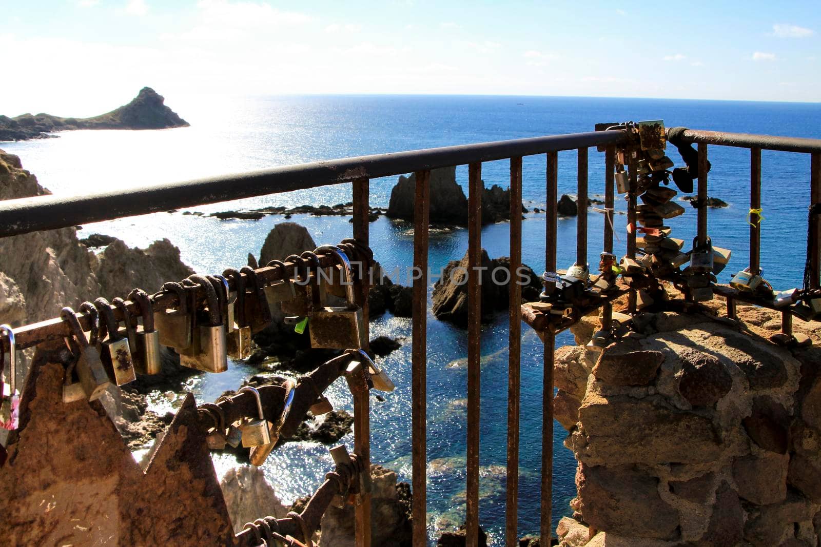 Romantic padlocks hanging on The Reef of the Sirens railing in Cabo de Gata-Nijar, Almeria, Spain