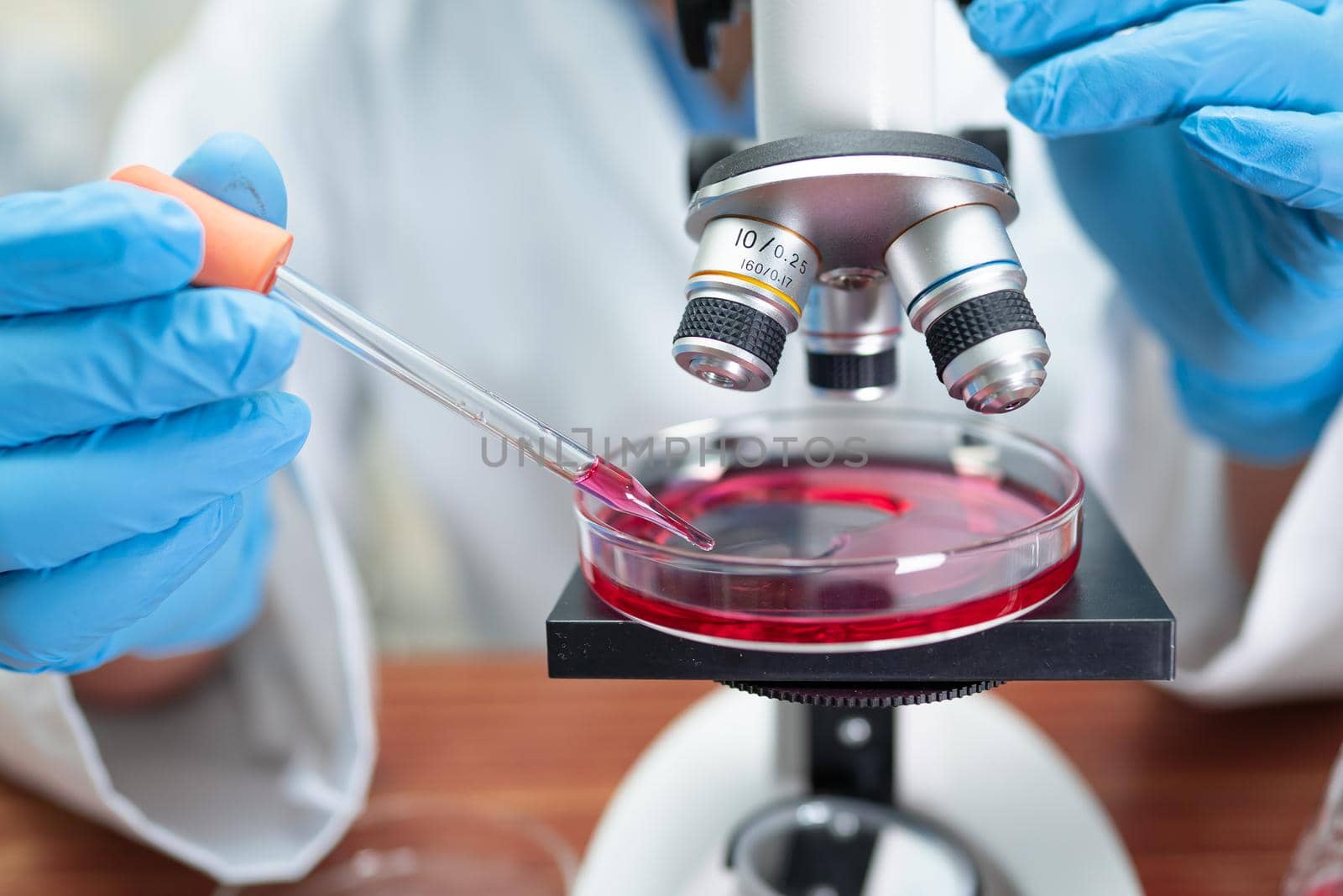 Asian scientist biochemist or microbiologist working research with a microscope in laboratory. For protect outbreak Coronavirus Covid19, bacteria and germs. by pamai