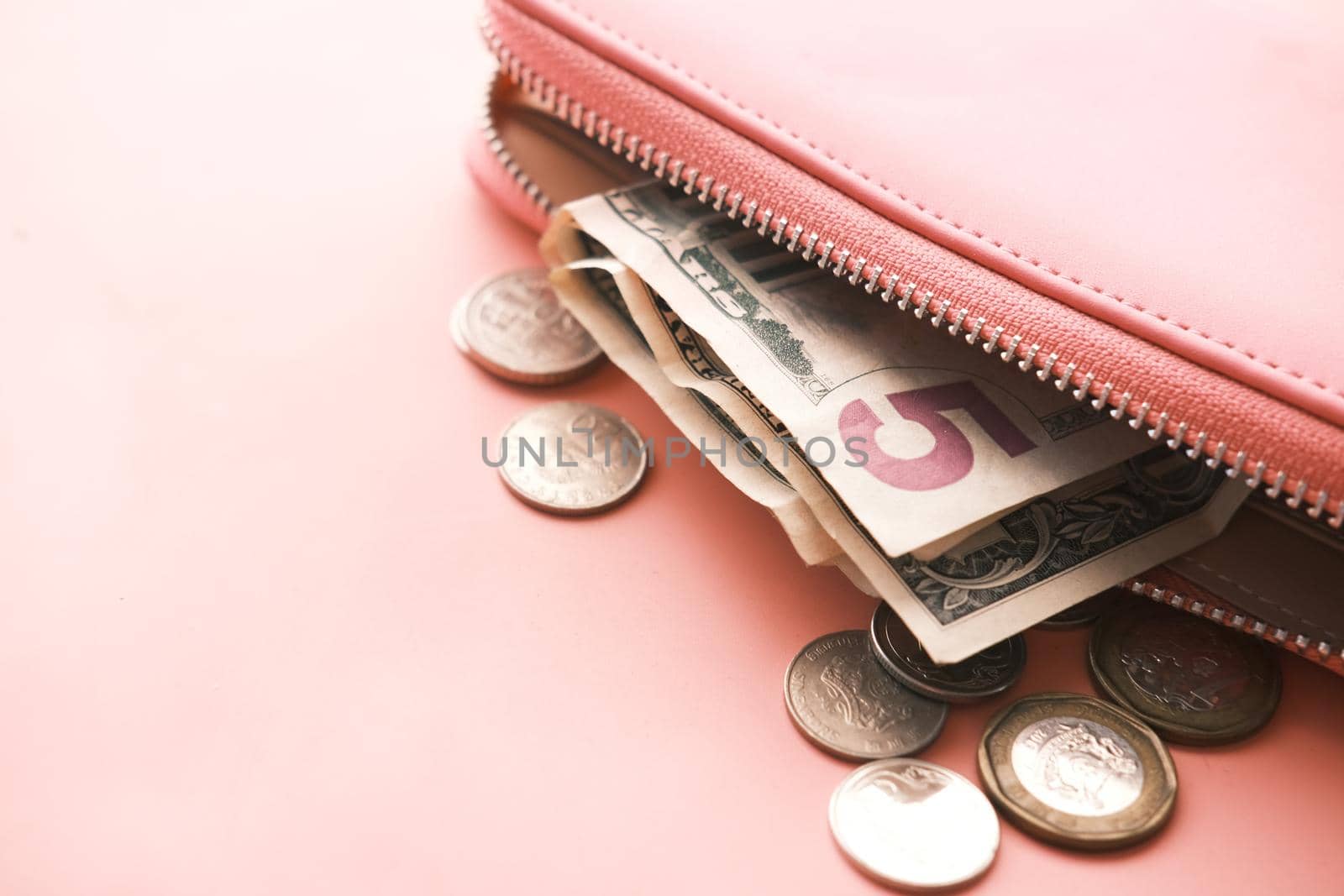 us dollar cash in leather on pink background .
