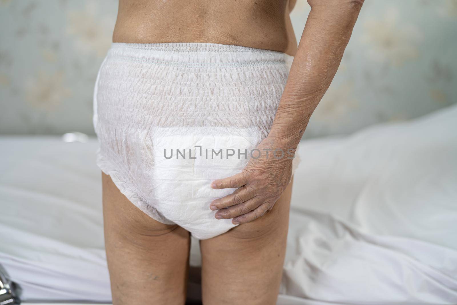 Asian senior or elderly old lady woman patient wearing incontinence diaper in nursing hospital ward, healthy strong medical concept.