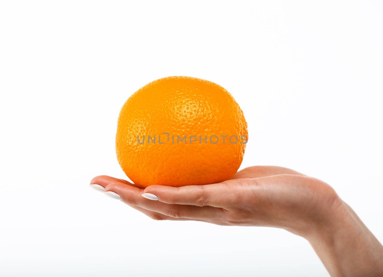 Close up Caucasian woman hand holding one fresh orange fruit isolated on white background, symbol of healthy eating concept, low angle, side view