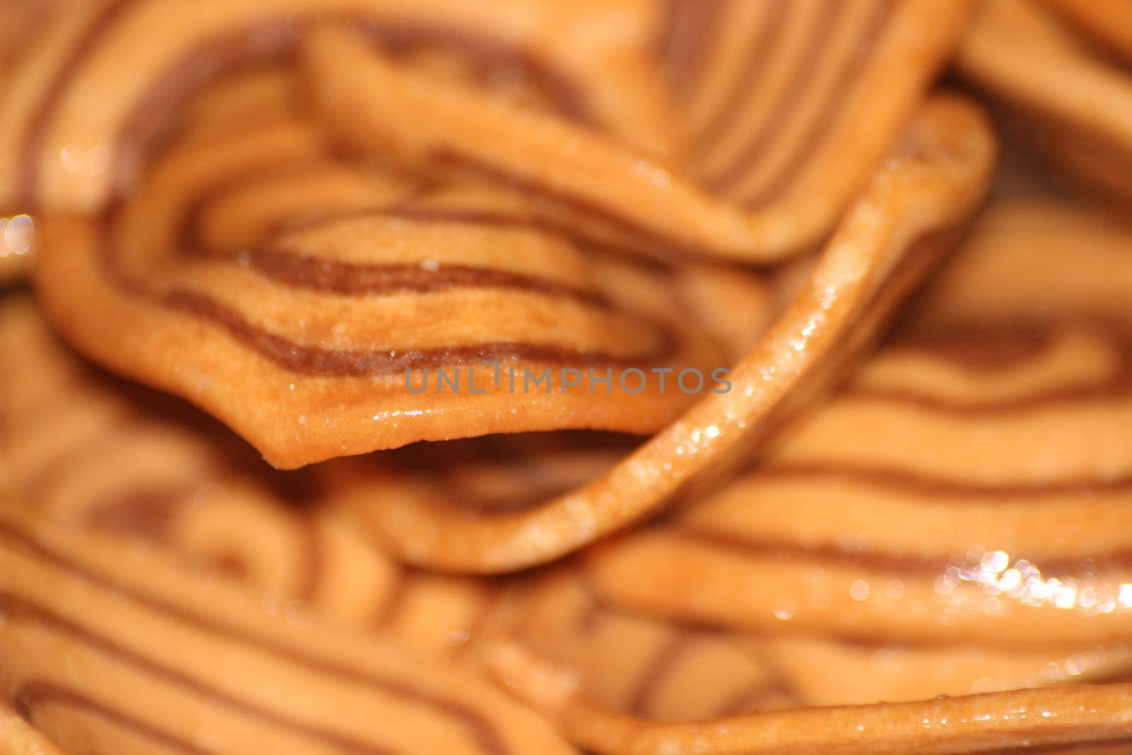 Closeup view with selective focus of a large number of round cookies with coconut filling lines.
