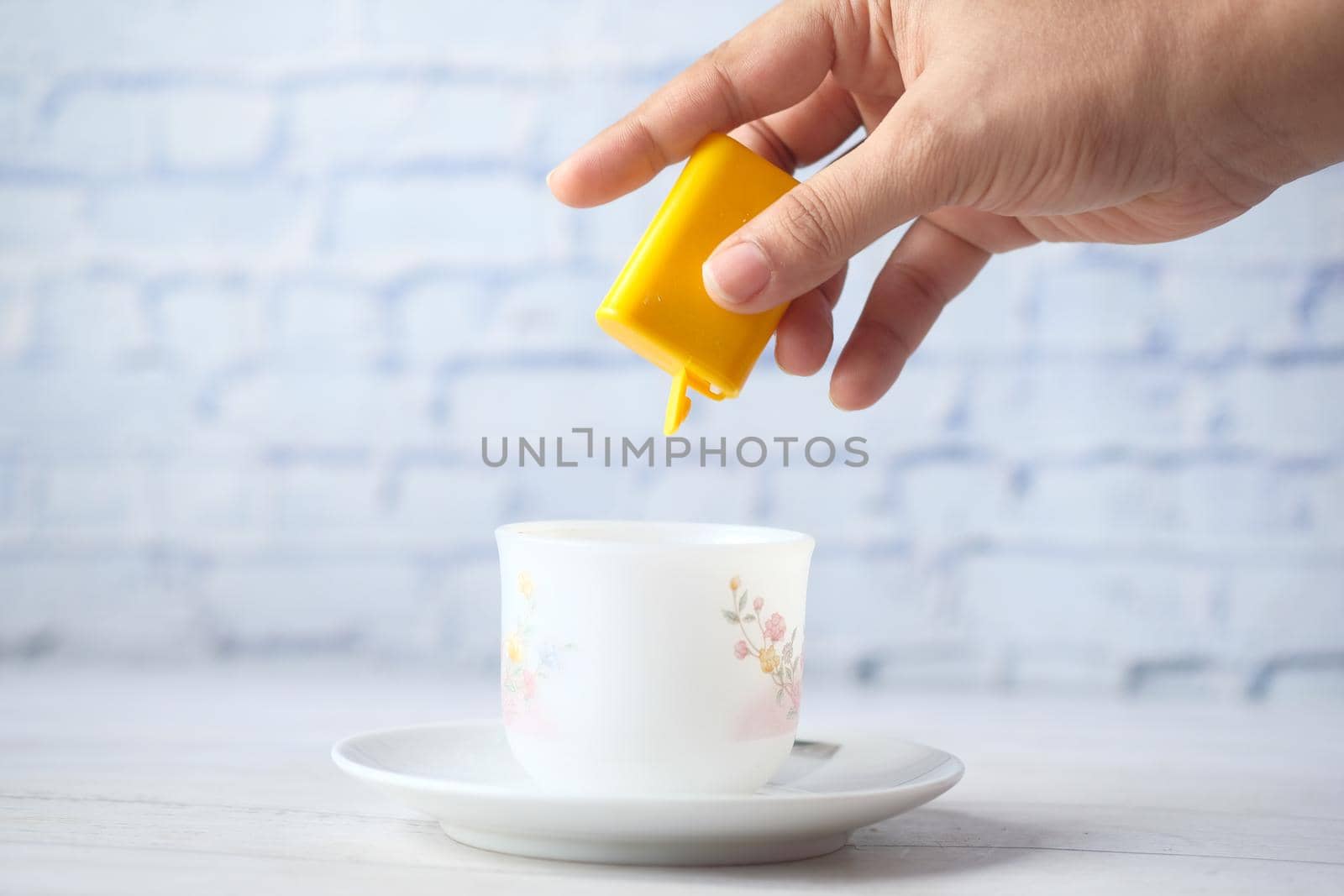 young women putting artificial sweetener in tea