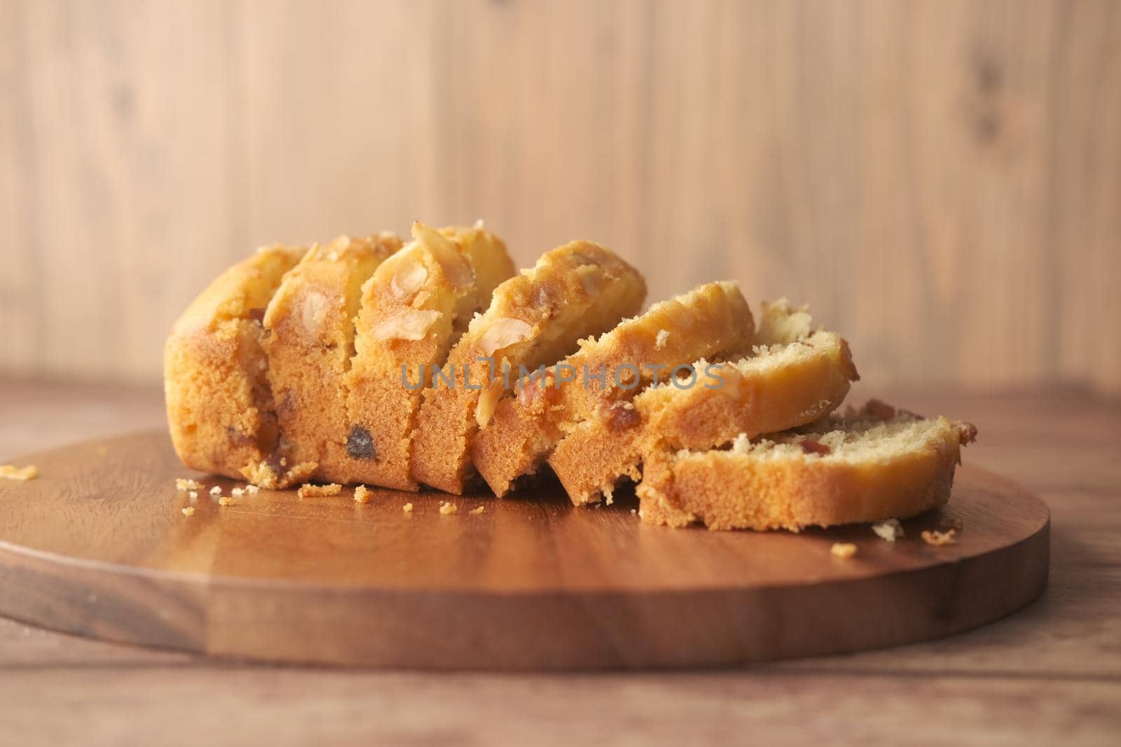 slice of bakery fruit cake on chopping board ,