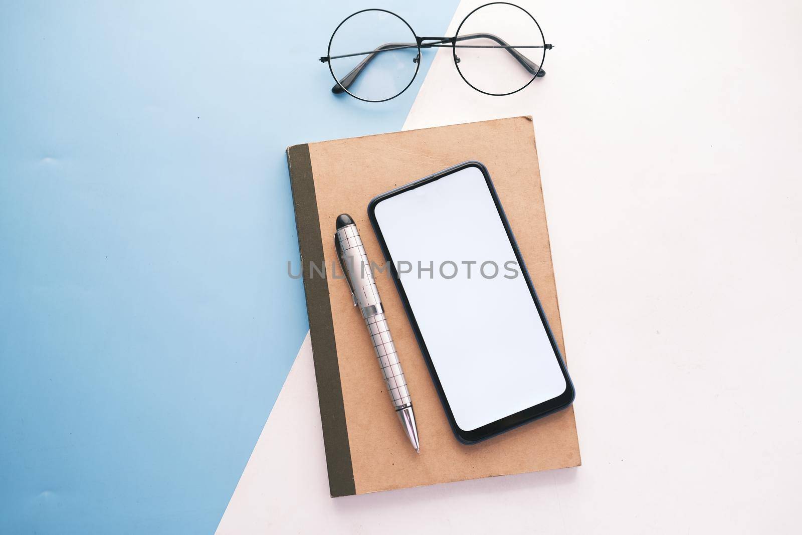 top view of smart phone and notepad on table .