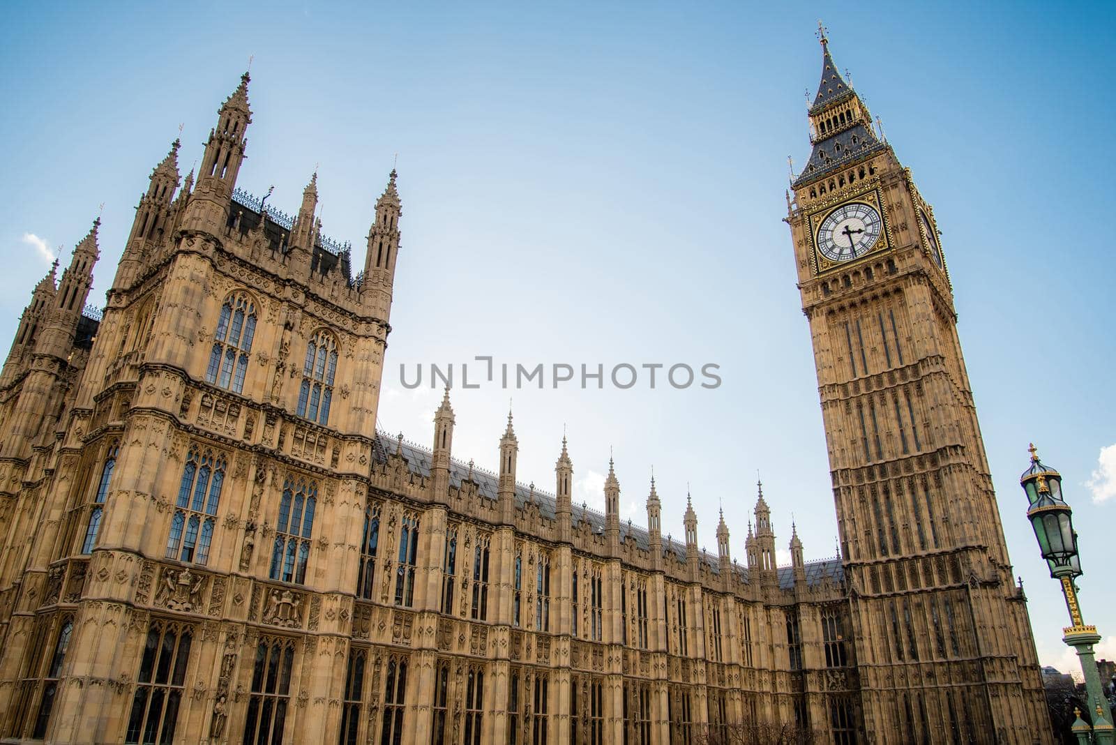 Wide angle close up of the Big Ben clock tower and Parliament gorgeous architecture with clear blue skies. by jyurinko